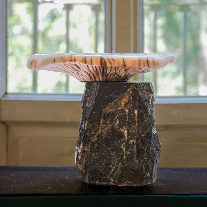 Handcrafted sculptural marble object by OnEntropy, featuring a raw dark stone base and translucent pink top, photographed in natural light at the Athens atelier.